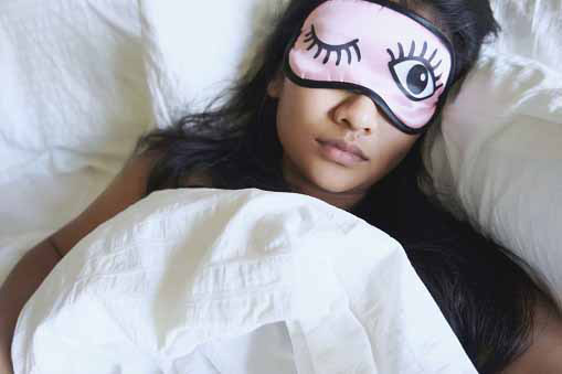 sleeping young woman wearing eye mask